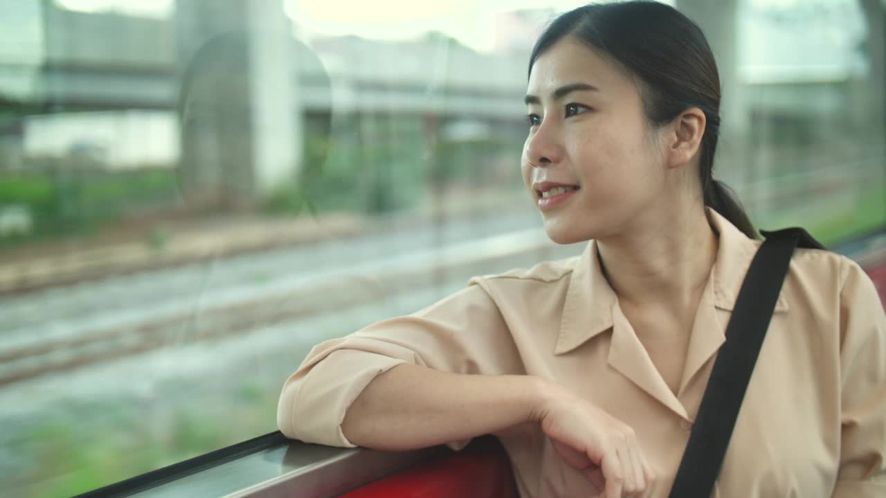 在火车上向窗外看的年轻女子视频素材