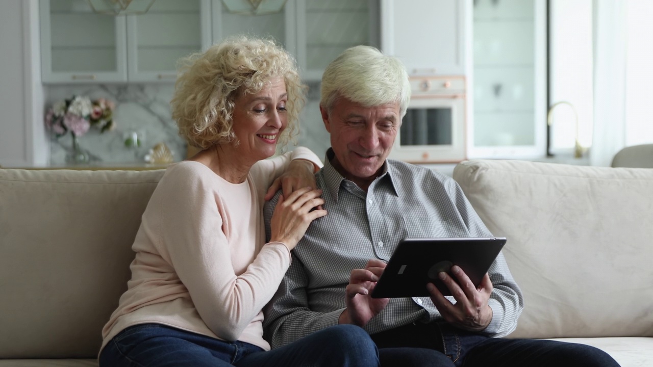 愉快的老年妻子和丈夫使用，讨论互联网应用程序视频素材
