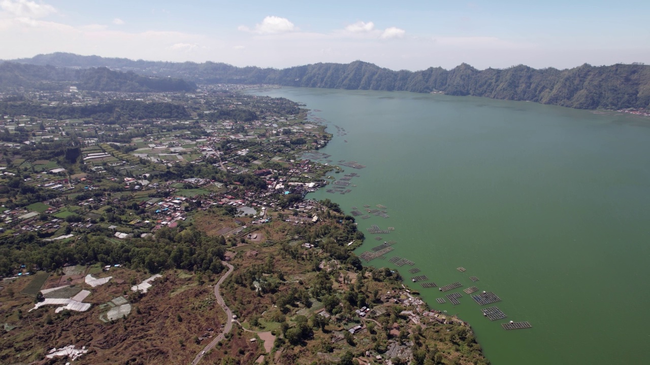 巴图尔火山口湖平坦岸边的建筑和农田，航拍视频下载