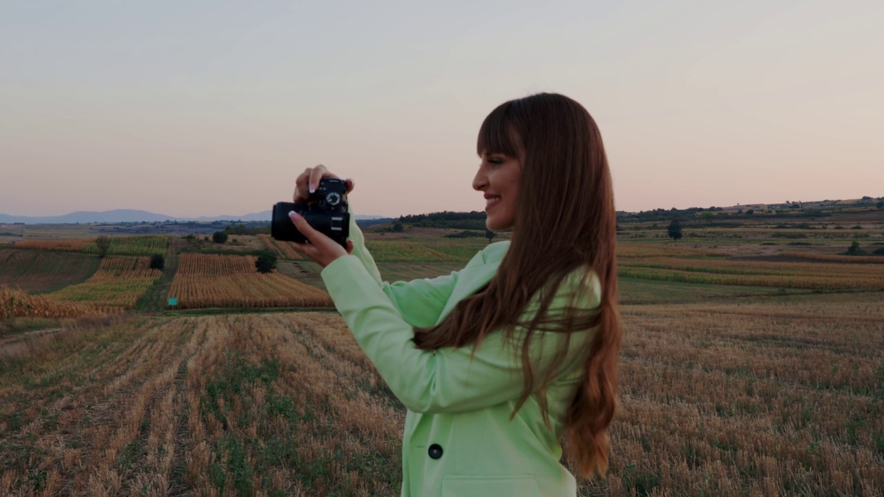 年轻时尚的女人在大自然中用相机拍照视频下载