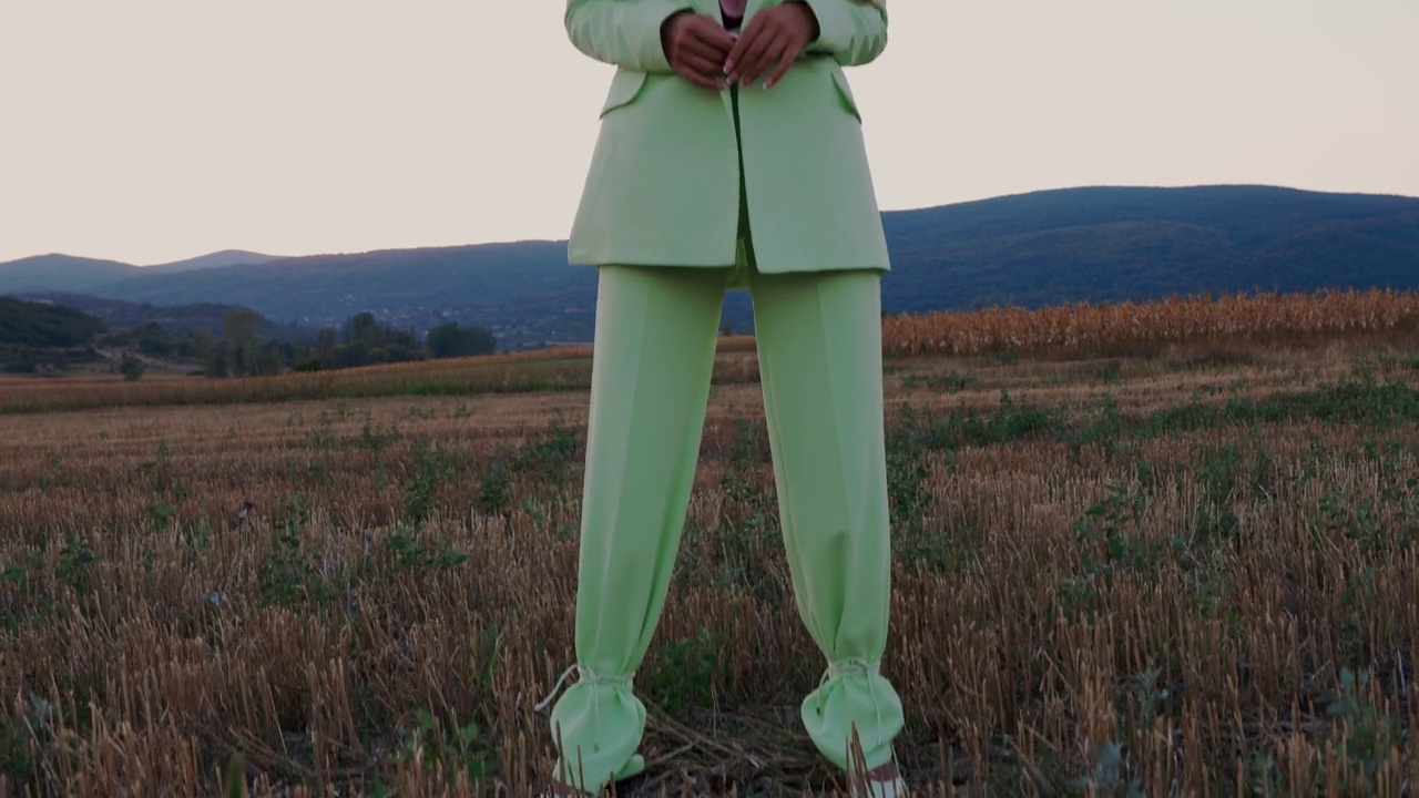 时尚的女人穿着薄荷绿色的套装在大自然中视频下载
