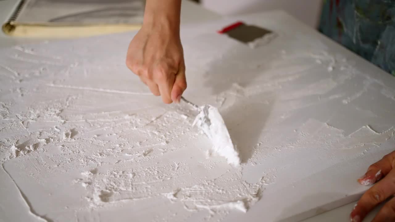 b卷无法识别的女艺术家在画布上用亚克力腻子和抹刀做艺术视频素材