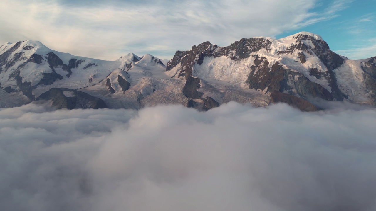 空中拍摄的瑞士阿尔卑斯山高雪山在瑞士移动拍摄在日出时间的云层之上视频素材