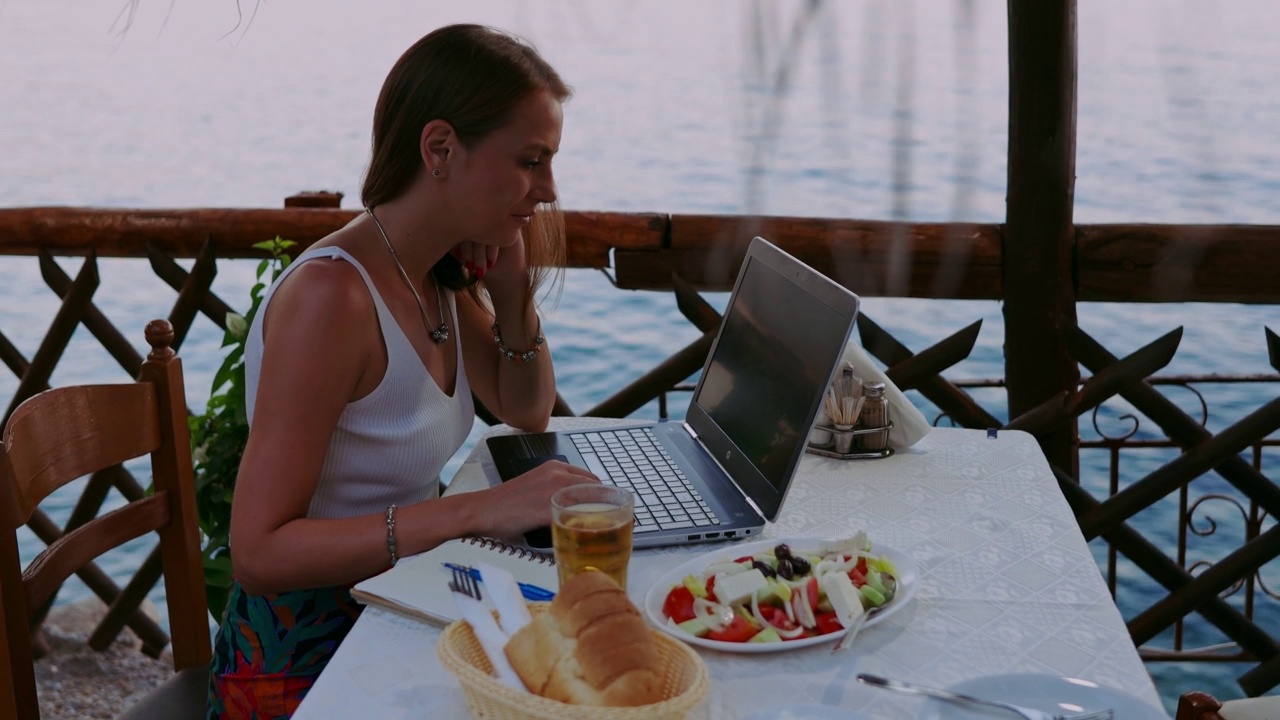 一名年轻女子在海滨餐厅做作业视频下载