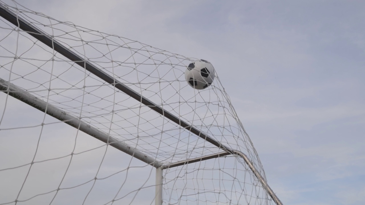 多利射门足球击中网在慢动作的目标视频素材