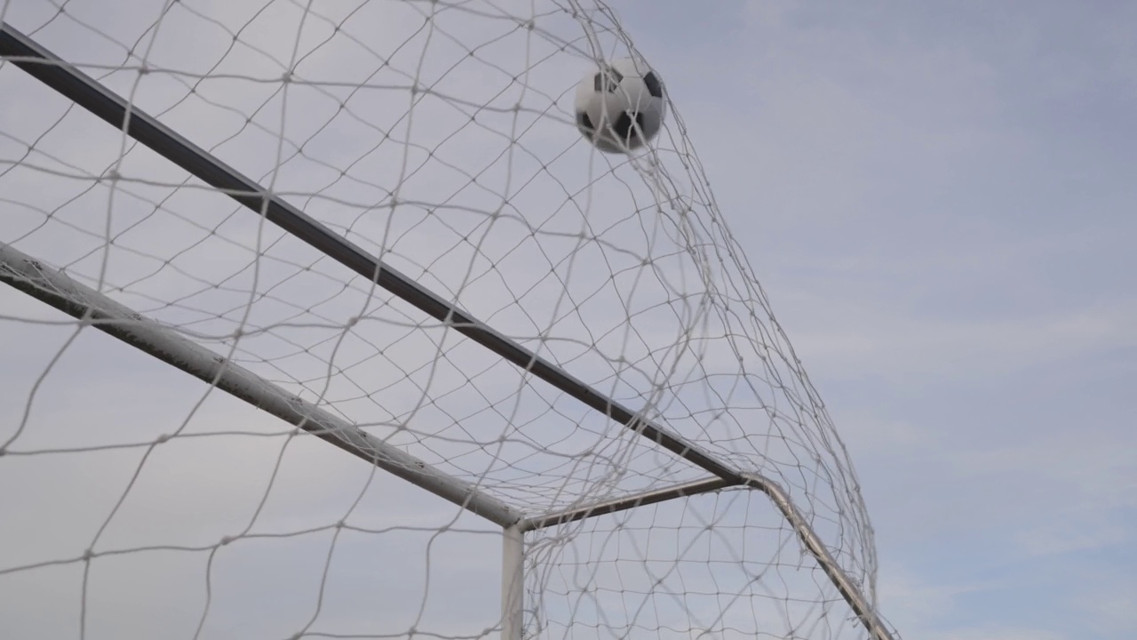 多利射门足球击中网在慢动作的目标视频素材