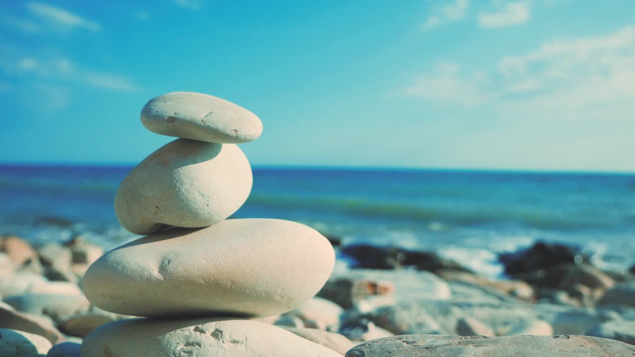 平衡与和谐。多岩石的海岸。前景是一排平衡石。脆弱和不稳定的世界。视频素材