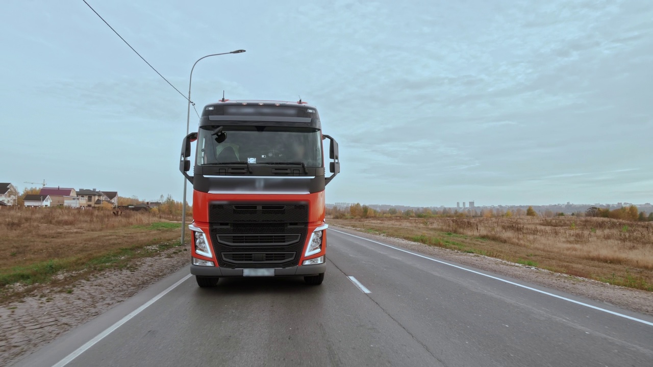 在多车道道路上单独行驶的带有货物拖车的卡车的正面视图视频下载