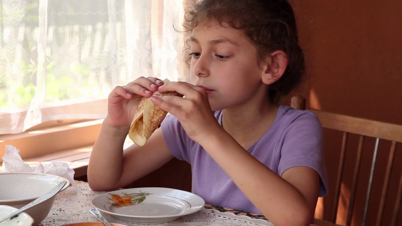 小女孩在吃煎饼卷视频素材