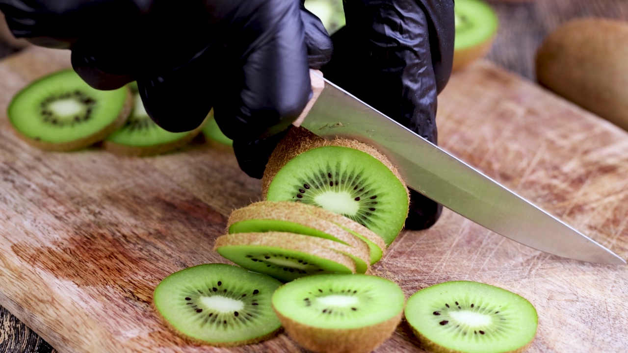 煮的时候把新鲜的绿色猕猴桃切成片放在砧板上视频素材