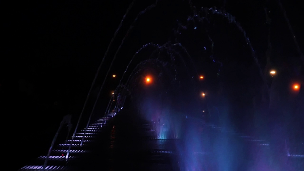 在彩色灯光下的慢动作喷泉表演视频素材