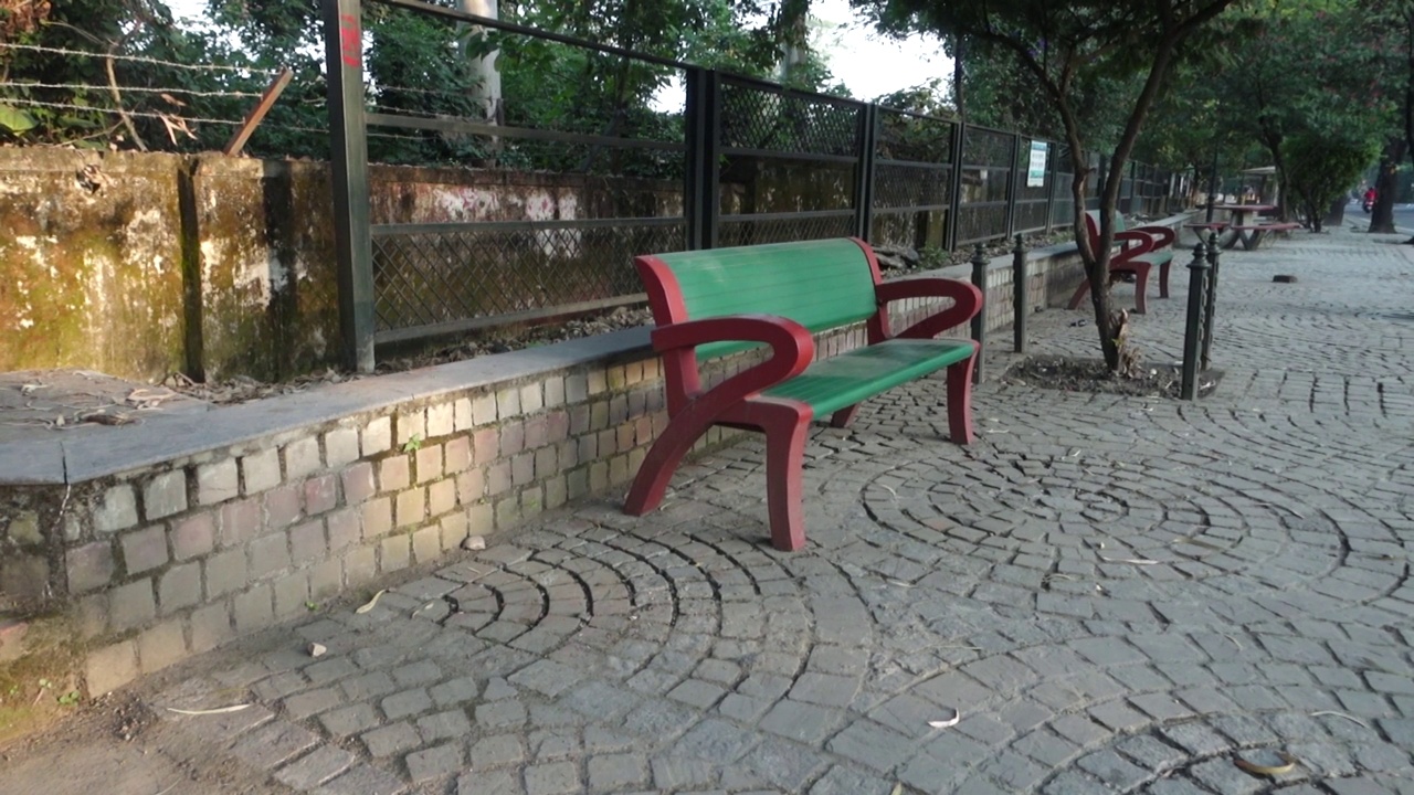 一张空旷的彩色人行道旁的公园长椅摄于印度。视频下载