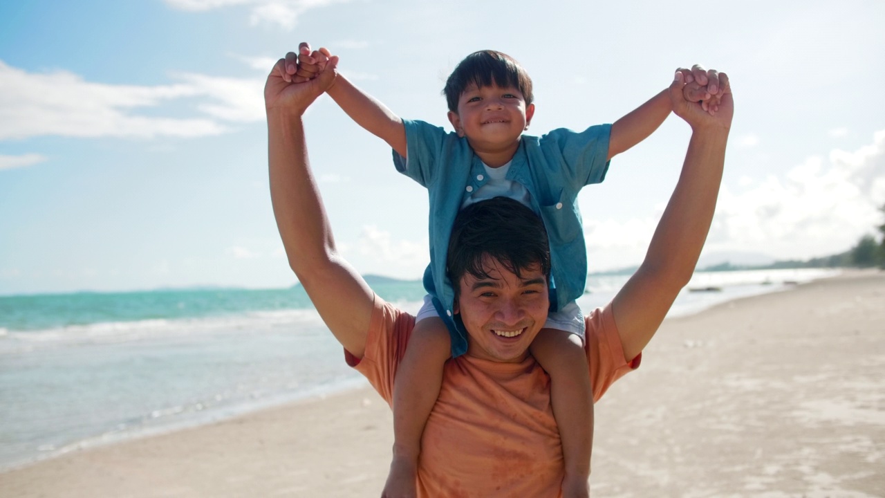 快乐的亚洲小男孩骑在父亲的脖子上视频素材