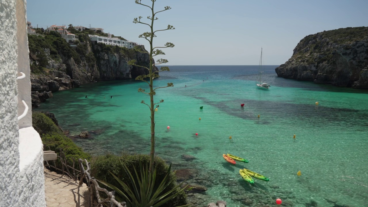 船在蓝绿色的水和海滩在卡拉恩波特，梅诺卡，巴利阿里群岛，西班牙，地中海，欧洲视频下载