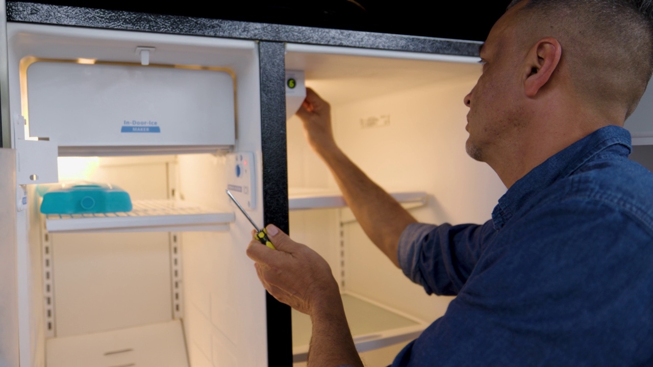 拉丁美洲的杂工正在修理家里的冰箱视频下载