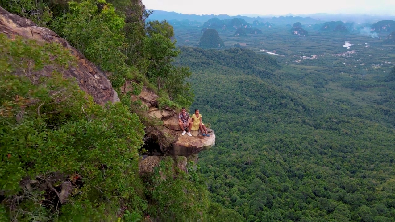 泰国甲米丛林中的龙冠岩，一对男女俯瞰着丛林视频下载