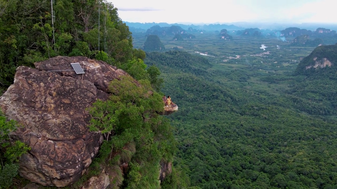 泰国甲米丛林中的龙冠岩，一对男女俯瞰着丛林视频素材