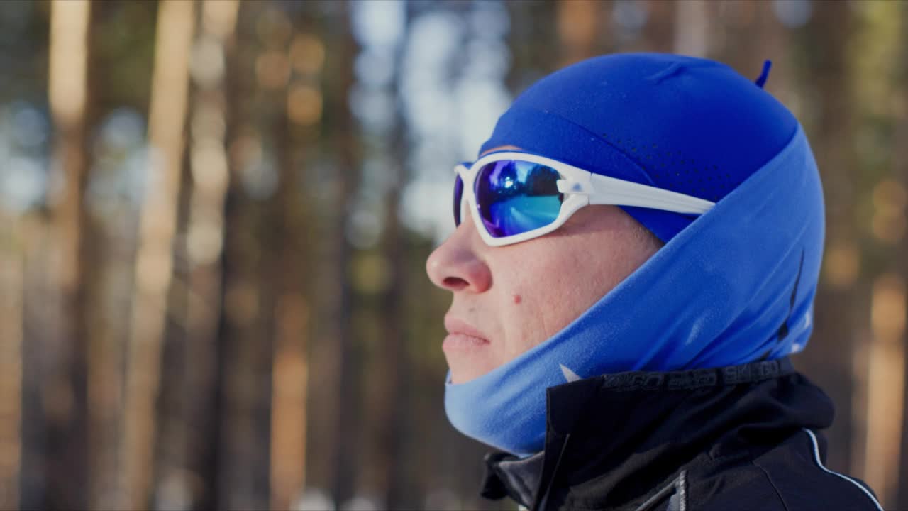 男子肖像在运动温暖的衣服，帽子和蓝色眼镜，侧视图。视频下载