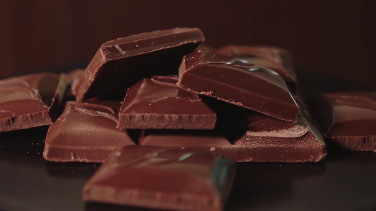 一堆黑巧克力放在旋转的架子上视频下载