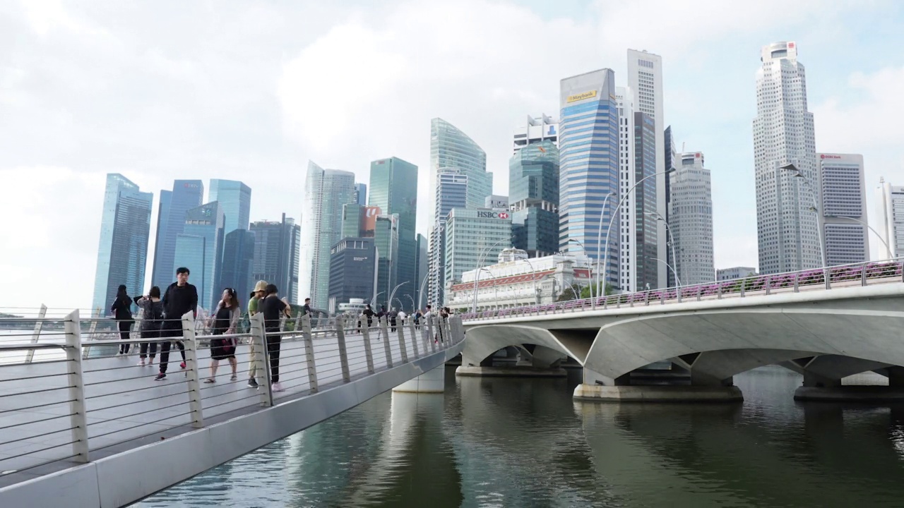 时间的流逝，城市的流逝，商业区的建筑，晴天天空中快速移动的云。在新加坡步行的游客。视频素材