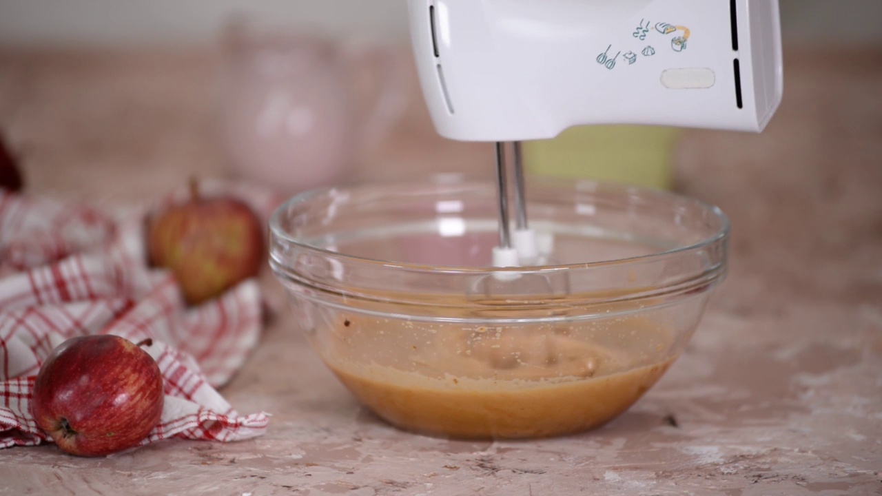 在一个大的玻璃搅拌盆里混合原料来烤苹果蛋糕。视频下载