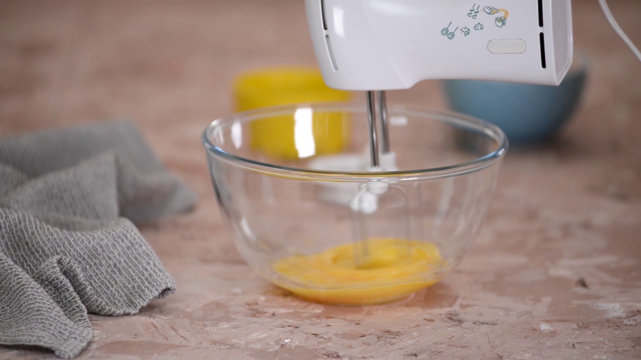 女人用桌上的搅拌器打鸡蛋，特写。视频下载