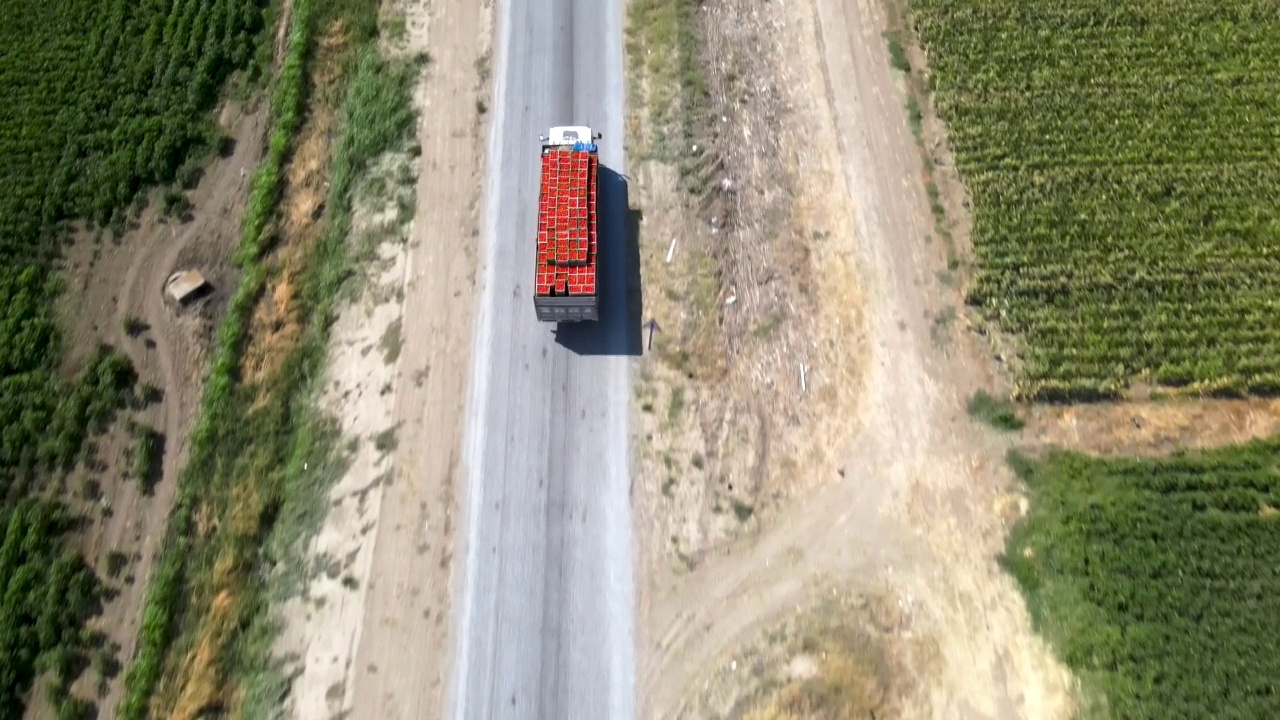 满载西红柿的卡车在路上行驶，鸟瞰图，4K视频视频下载