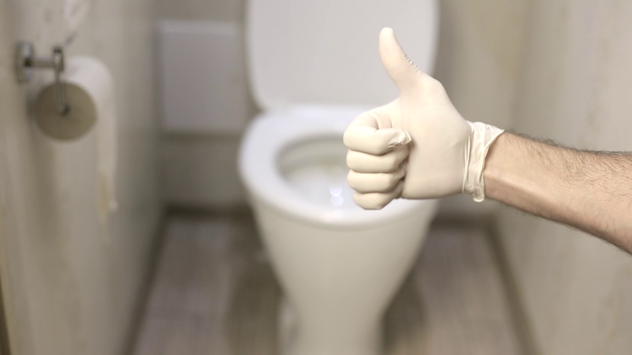 一名男子戴着白色乳胶手套在厕所背景上竖起大拇指视频下载