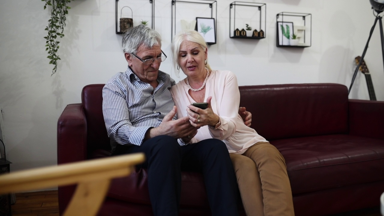 老年夫妇使用手机视频下载