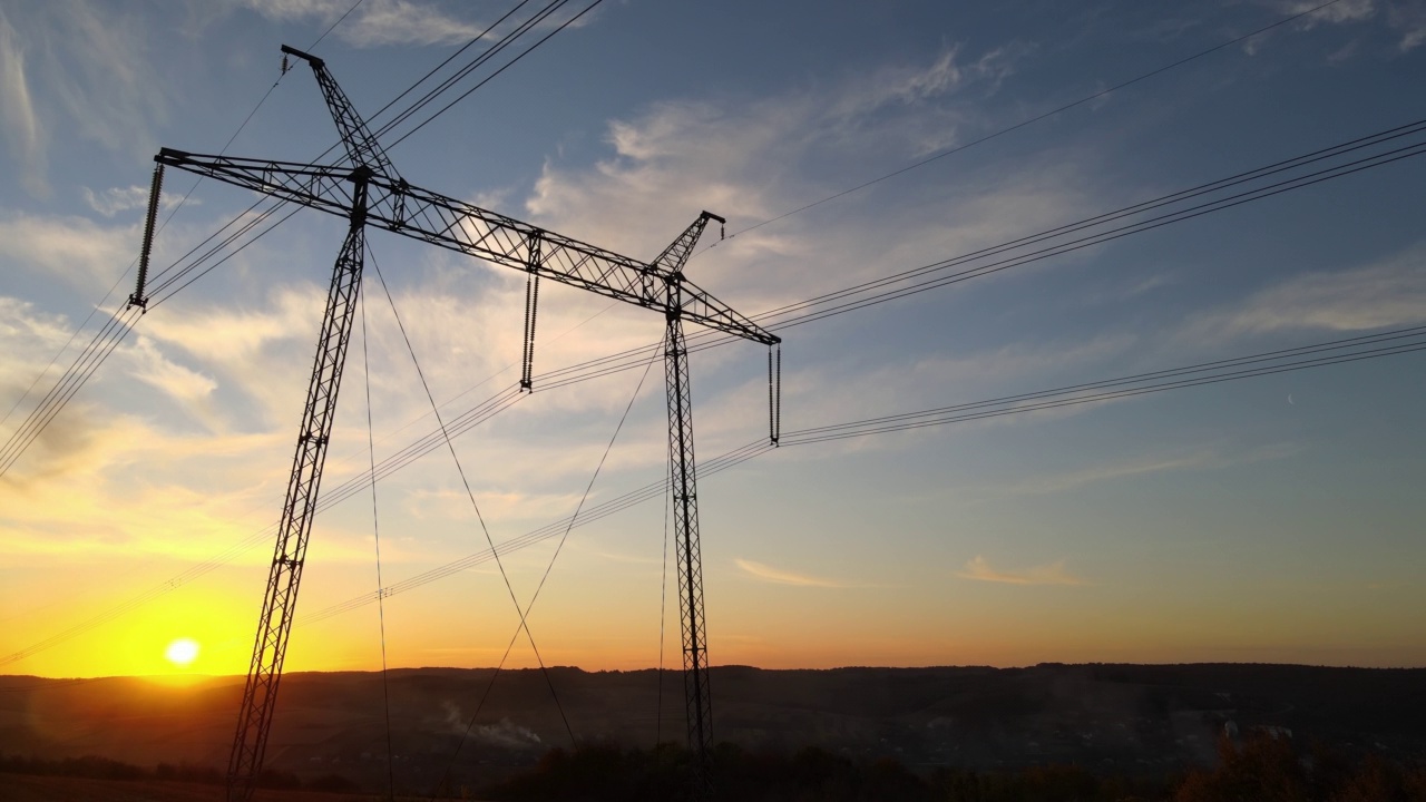 夕阳下的高压输电塔。传输的电力视频素材