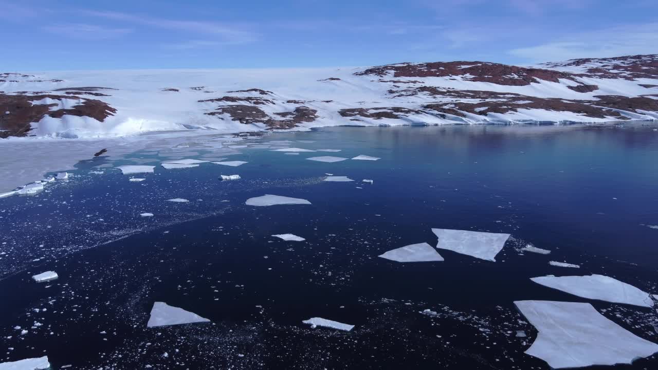 积雪覆盖的南极地面鸟瞰图飞行。视频素材