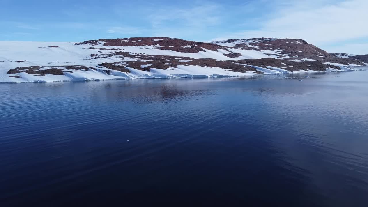 积雪覆盖的南极地面鸟瞰图飞行。视频下载