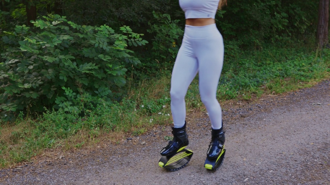 女人用智能手表看时间，穿着跳跃鞋锻炼视频下载