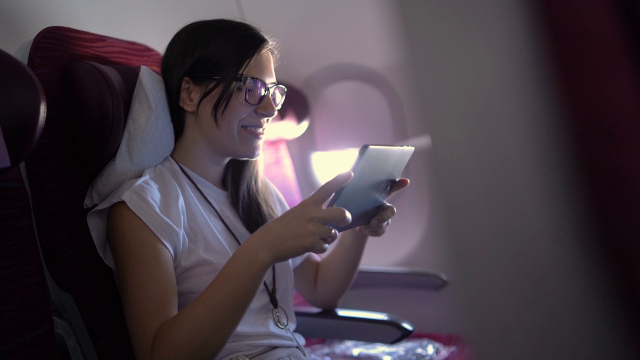女乘客在飞机上使用平板电脑视频素材
