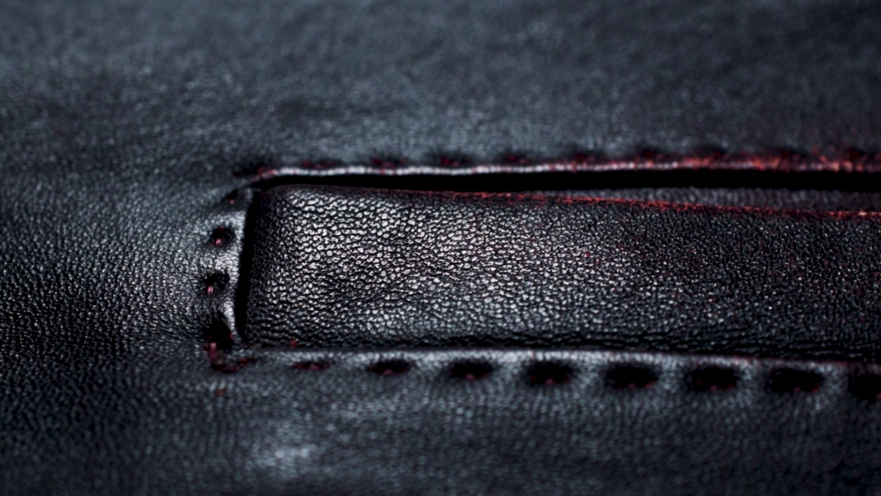 一件深红棕色皮夹克的口袋缝。特写皮革质地的时尚背景视频下载