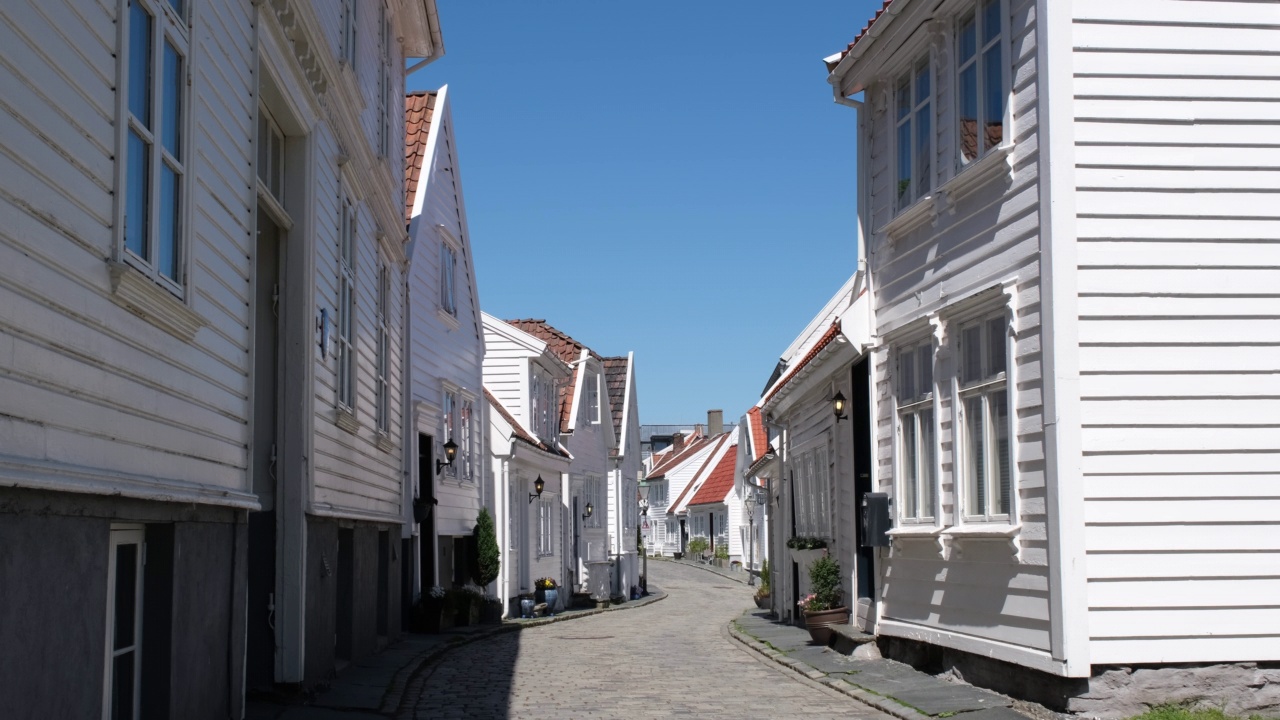 挪威斯塔万格。在一个阳光明媚的春日，老城的街景。罗格兰的Gamle Stavanger，有传统白色木屋的街道。鹅卵石路。4K超高清59,94fps ProRes 422 HQ 10位视频素材