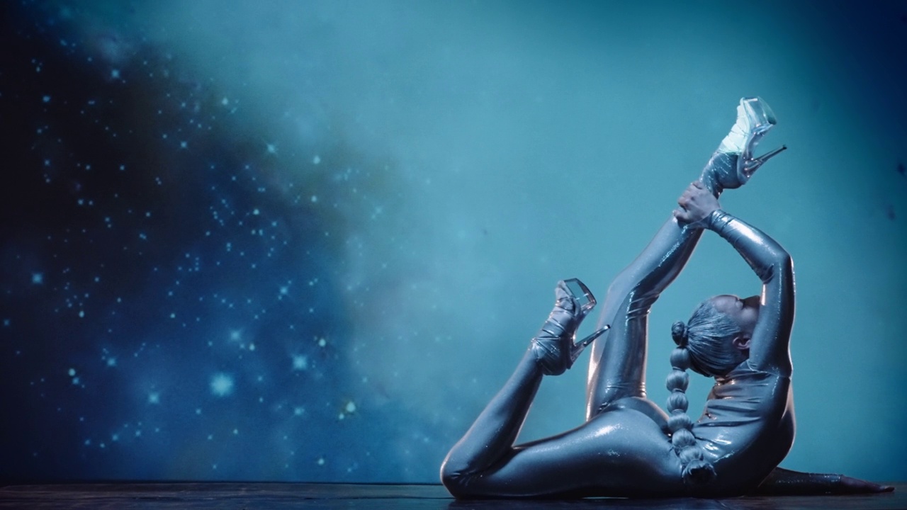 灵活的女子柔术表演在舞台上对星空的空间回来视频下载