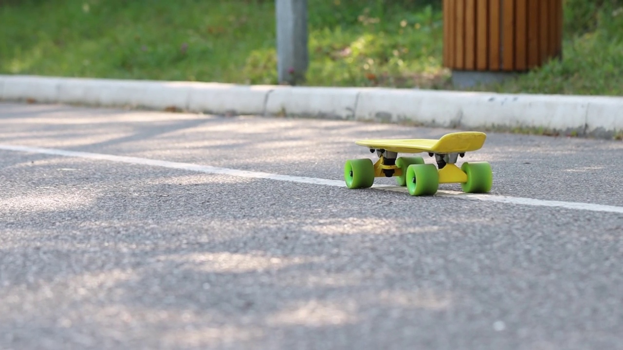 空的黄色滑板滚下柏油路。街头滑板视频素材
