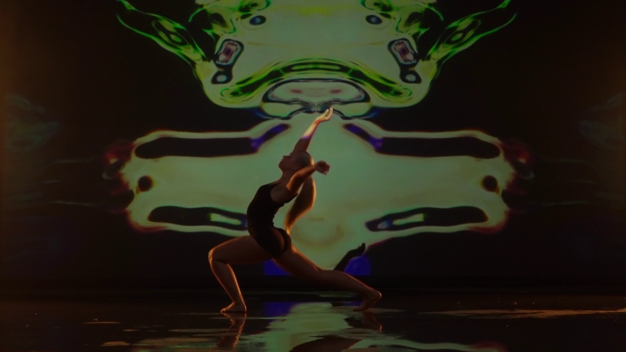 艺术年轻女子在工作室的舞台上在黑暗动画背景下跳舞视频下载
