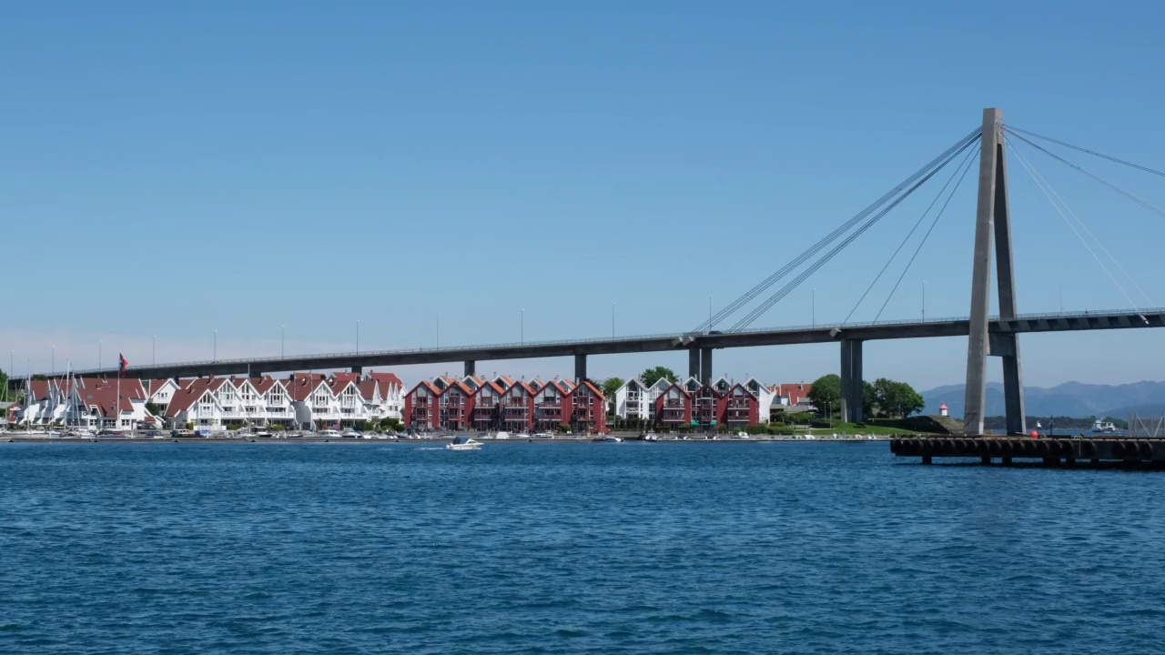 挪威斯塔万格。从港口俯瞰现代挪威小镇的全景。峡湾上的大桥。白色和红色的房子。汽艇在海面上划动。阳光明媚的一天。4K超高清59,94fps ProRes 422 HQ 10位视频素材