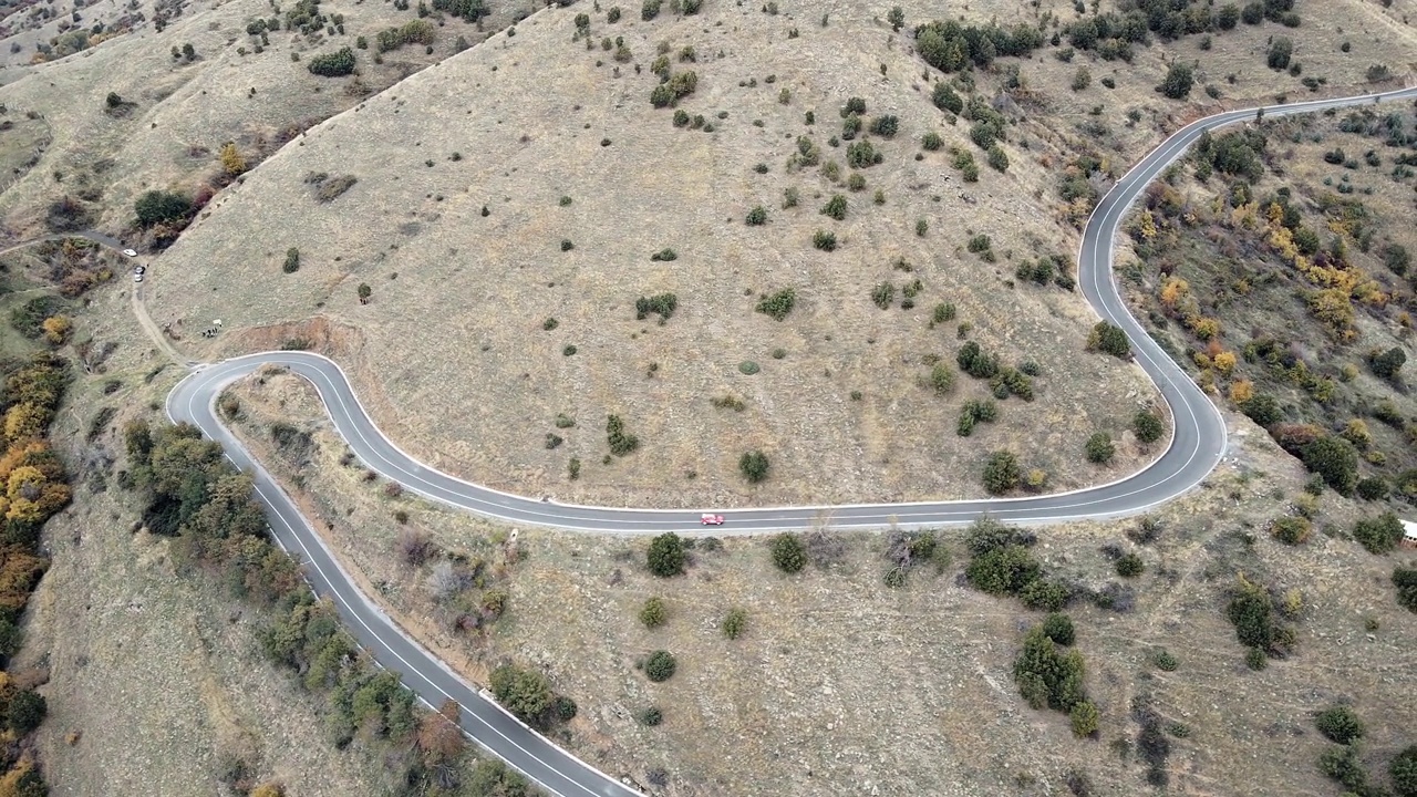 定制跑车在秋天的爬坡比赛中飞驰在弯曲的山路上视频下载