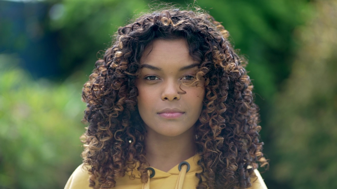 肖像脸特写的巴西黑人年轻女性卷发看着相机。非裔美国西班牙裔拉丁裔女孩站在户外视频下载