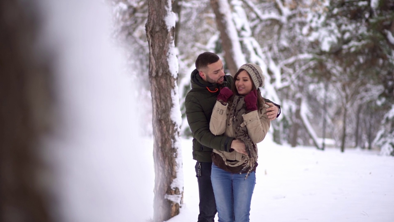 一对年轻的情侣在下雪的公园里接吻视频下载