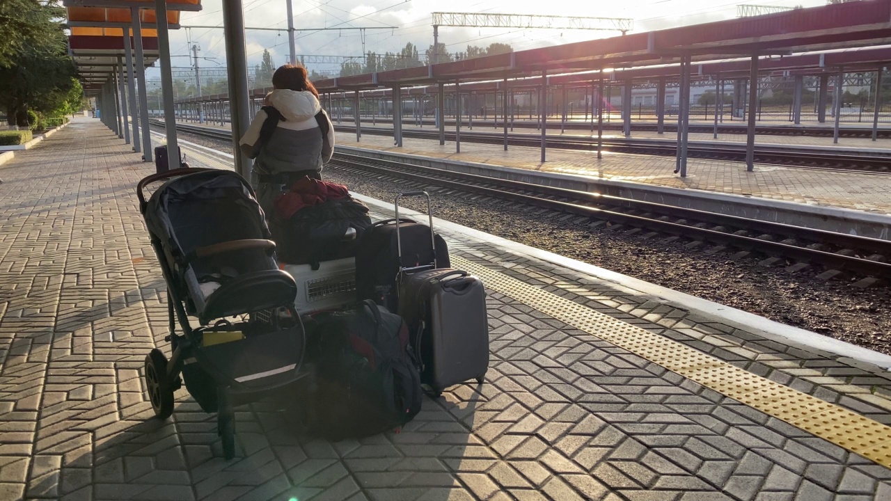 一家人带着小孩坐火车旅行，一名妇女带着婴儿和行李在辛菲罗波尔火车站站台等待火车的到来。视频下载