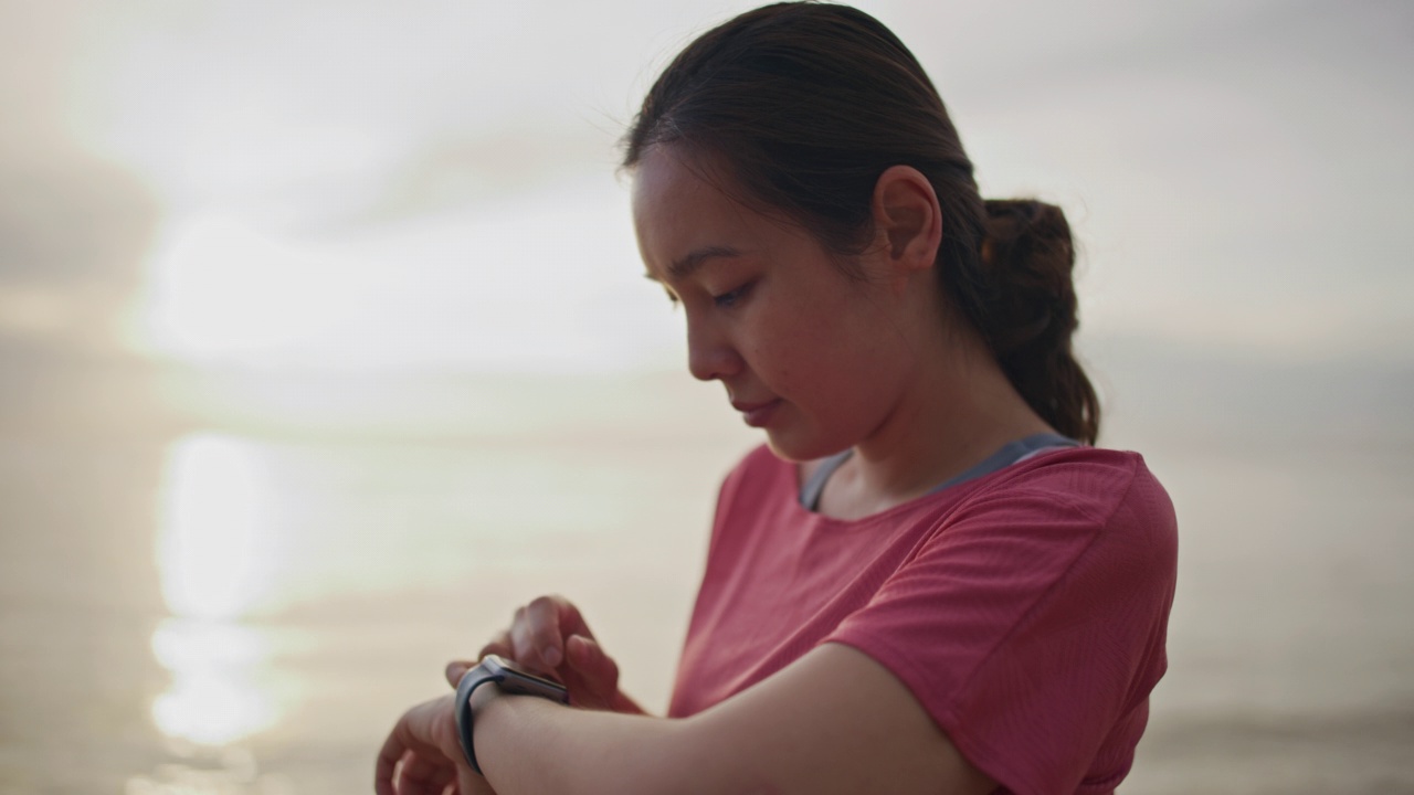 亚洲运动女性使用智能手表视频素材