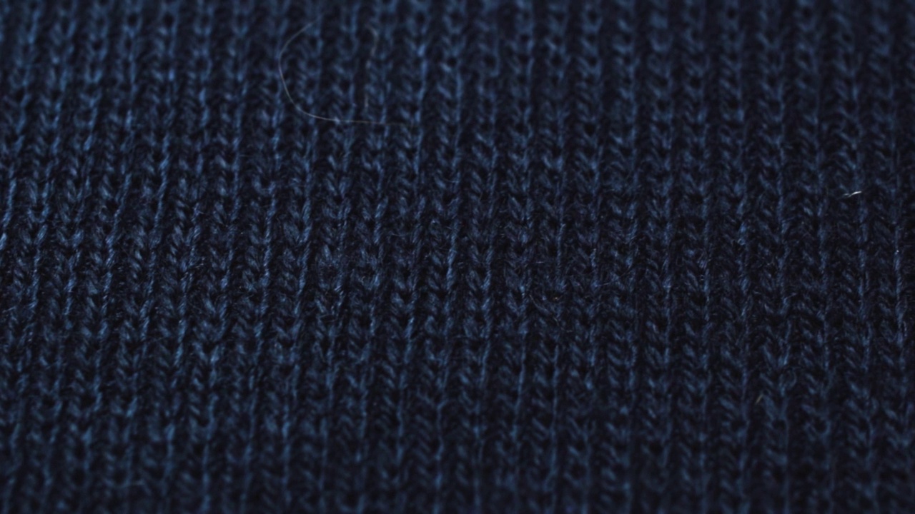 深蓝色针织面料质地。特写详细的毛衣织物背景。柔软的羊毛纺织图案为冬季时尚背景视频下载