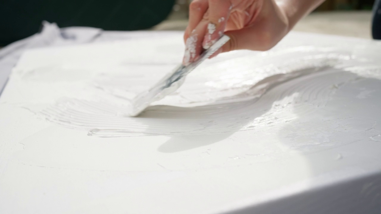 b卷无法识别的女艺术家在画布上用亚克力腻子和抹刀做艺术视频下载
