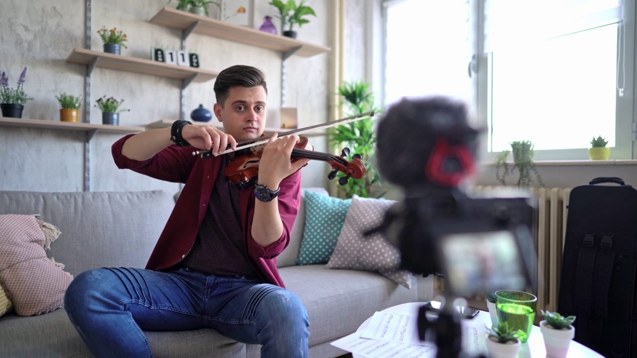 男人一边拉小提琴一边写视频视频素材