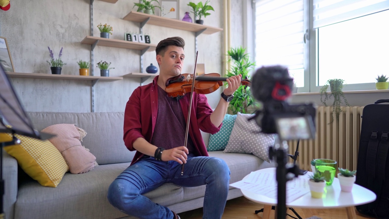 男人一边拉小提琴一边写视频视频素材