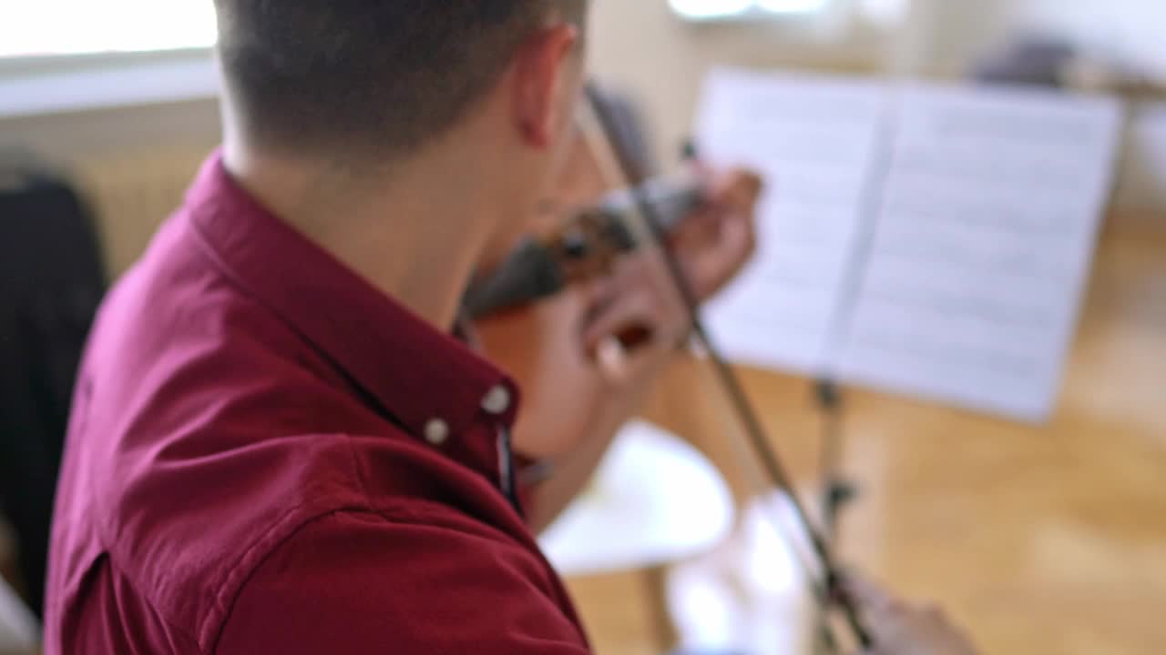 年轻的小提琴手在家练习视频素材